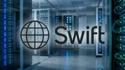 A server room with racks of computer hardware, overlaid by the SWIFT logo featuring a globe and the word Swift.