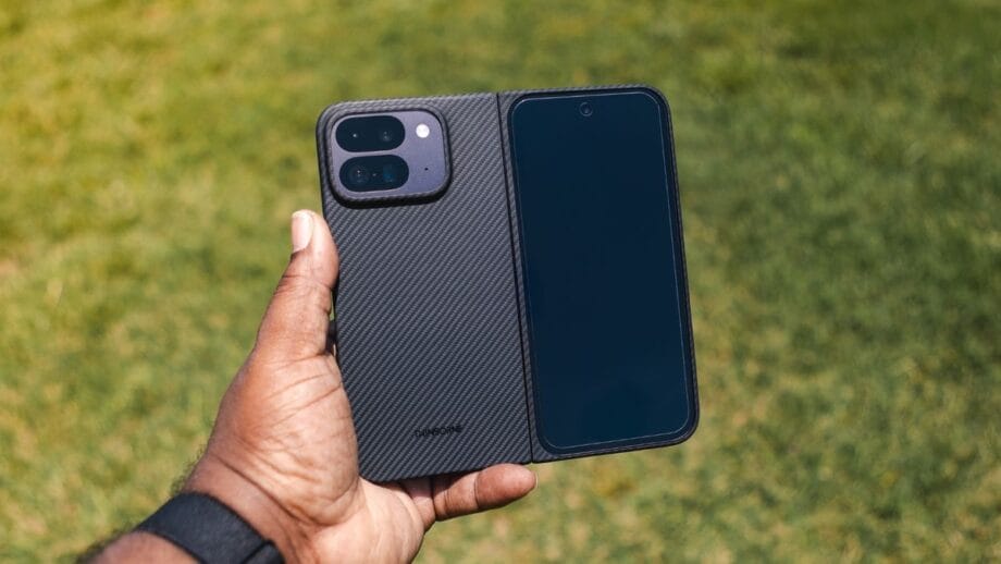 A hand holding an open folding smartphone with one side showing the screen and the other side showing the cameras.