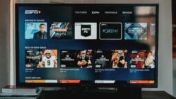 Television displaying the ESPN+ streaming interface with sports programs, team yearbooks, and event replays visible on the screen.
