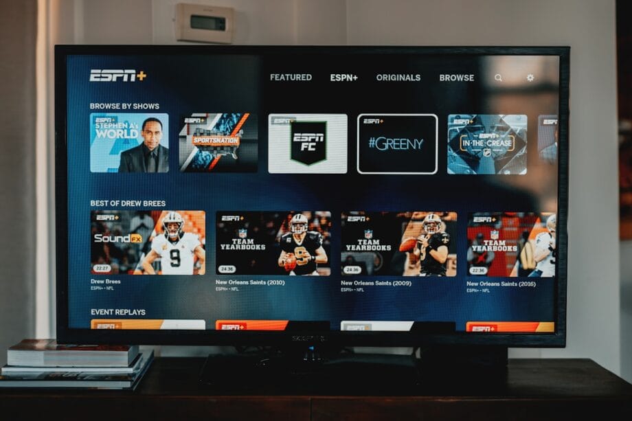 Television displaying the ESPN+ streaming interface with sports programs, team yearbooks, and event replays visible on the screen.