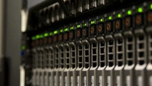 Close-up of server rack with multiple hard drive bays and indicator lights in a data center.