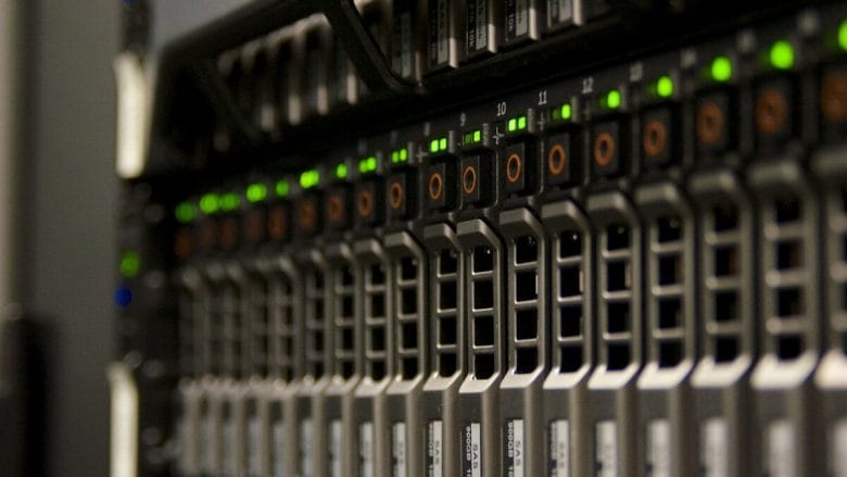 Close-up of server rack with multiple hard drive bays and indicator lights in a data center.