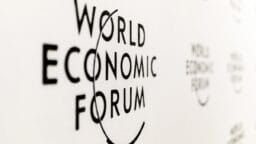 The World Economic Forum logo is displayed in black text on a white wall.