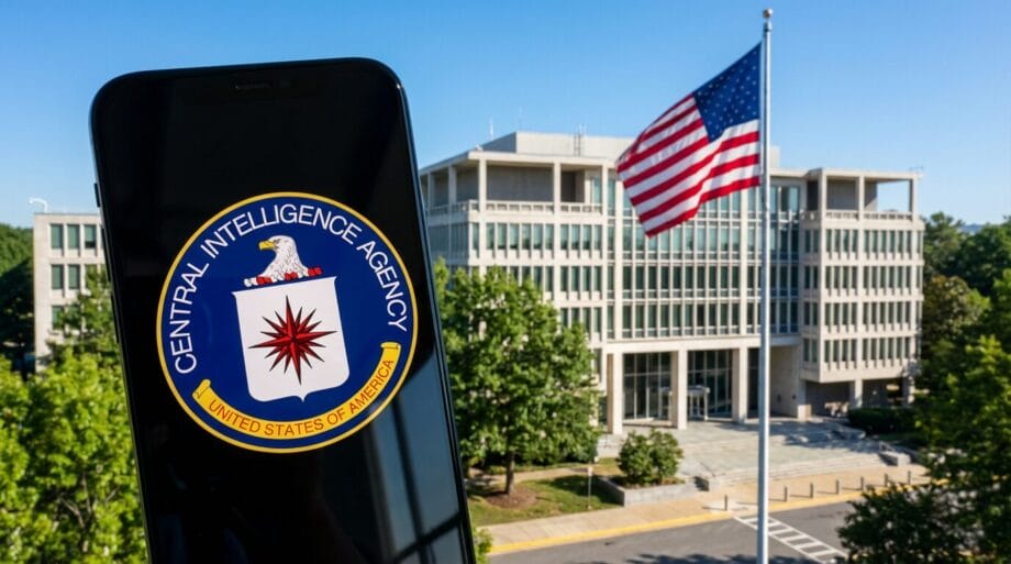 A smartphone displays the Central Intelligence Agency logo in front of the CIA headquarters building with a US flag outside.