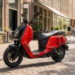 A red and black scooter on a brick street.