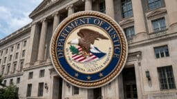 The Department of Justice seal displayed in front of a large government building.