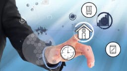 A person touches virtual icons, including a house, clock, binoculars, charts, and a smartphone, on a digital interface.