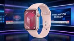 A pink Apple Watch Series 9 is displayed in front of a digital news studio background with tech news headlines.