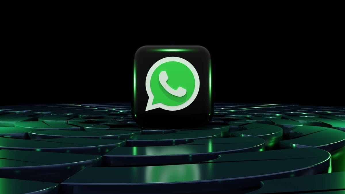 A 3D WhatsApp logo cube sits on a dark, glowing, circular platform with green highlights against a black background.