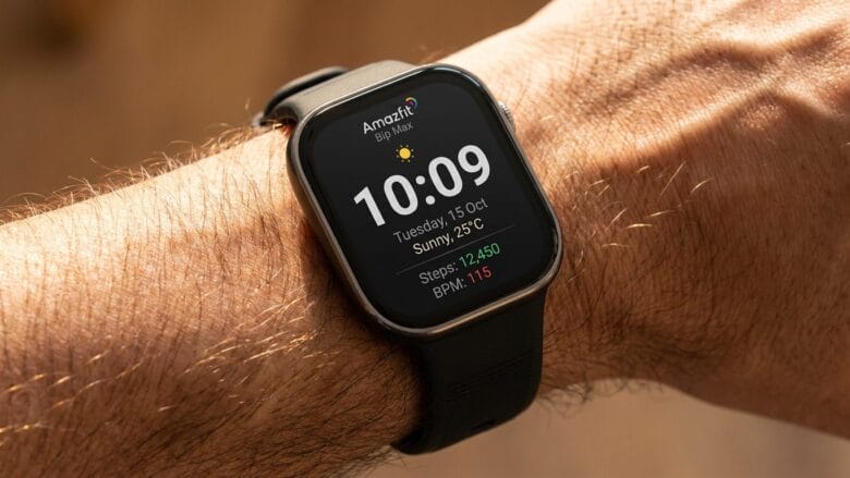 A smartwatch on a persons wrist displays the time, date, weather, step count, and heart rate on its home screen.