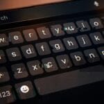 A close-up of a smartphone screen showing a virtual keyboard and a search bar at the top.