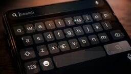 A close-up of a smartphone screen showing a virtual keyboard and a search bar at the top.