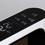 Close-up of a digital control panel on a modern air purifier appliance displaying 22°C with several touch-sensitive buttons and icons.