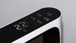 Close-up of a digital control panel on a modern air purifier appliance displaying 22°C with several touch-sensitive buttons and icons.
