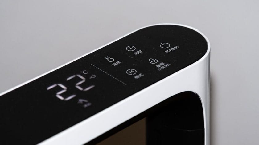 Close-up of a digital control panel on a modern air purifier appliance displaying 22°C with several touch-sensitive buttons and icons.