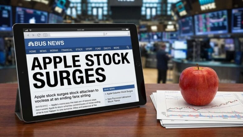 A tablet displays a news headline about Apple stock surging, with an apple and financial charts on a desk in a busy stock market setting.