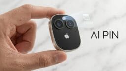 A hand holds a small, sleek device with two camera lenses and an Apple logo; a digital calendar projection appears above it with text AI PIN.