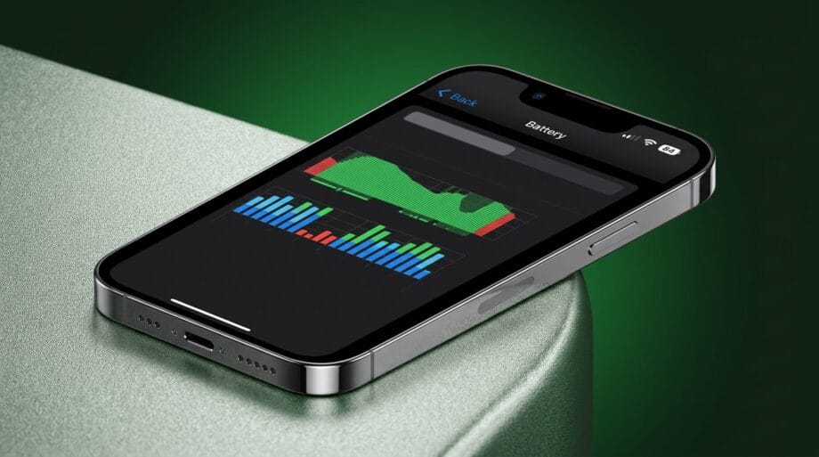 IPhone displaying battery usage statistics on its screen, resting on a green metallic surface with a dark green background.