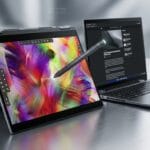 A convertible laptop in tent mode displays digital art with a stylus, next to an open laptop showing a webpage on a metallic surface.